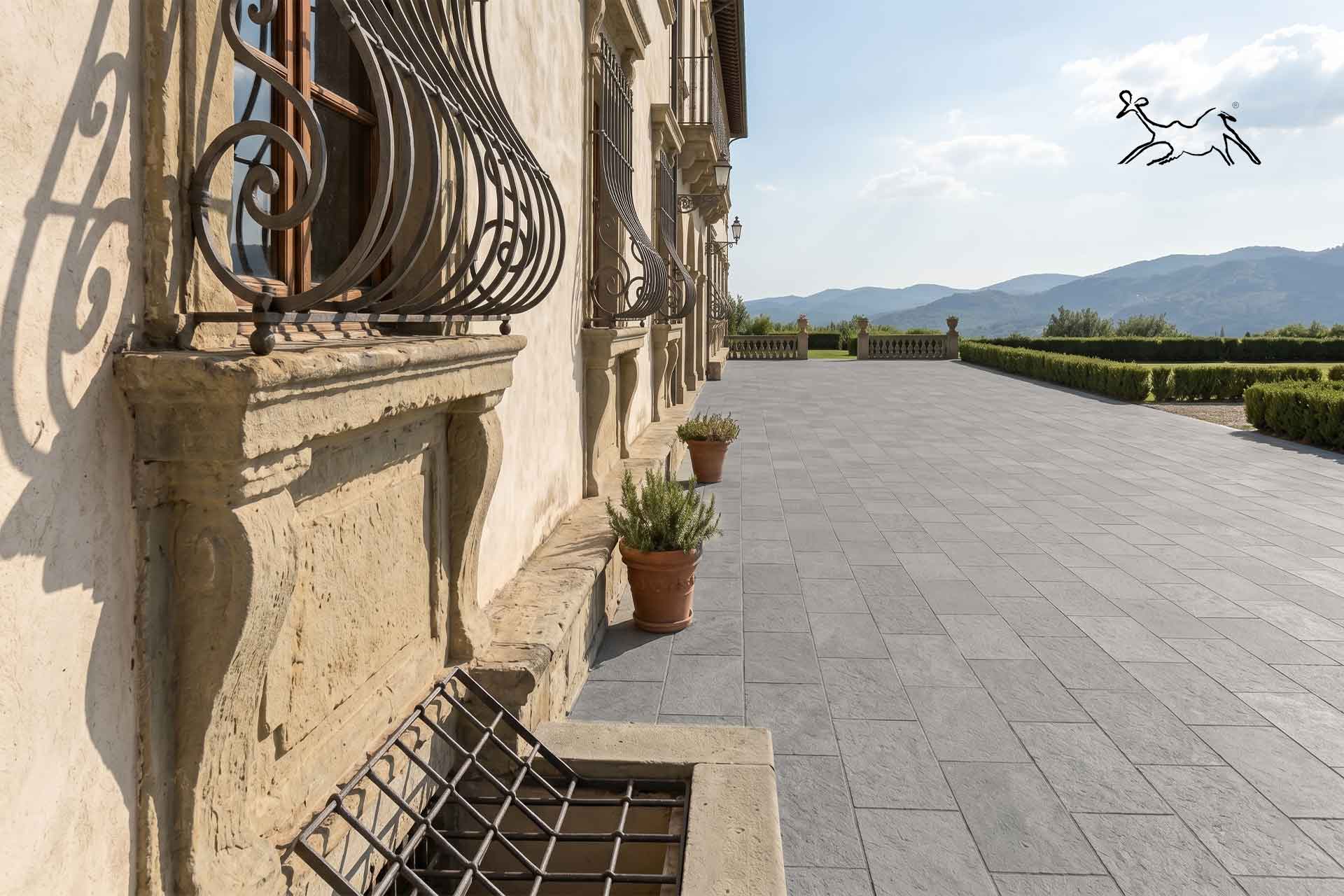 Pavimento esterno in pietra naturale grgia in formato rettangolare, calibrato, realizzato in terrazza di villa contemporanea, con lastre in pietra ideali per spazi outdoor, porticati e residenze di pregio