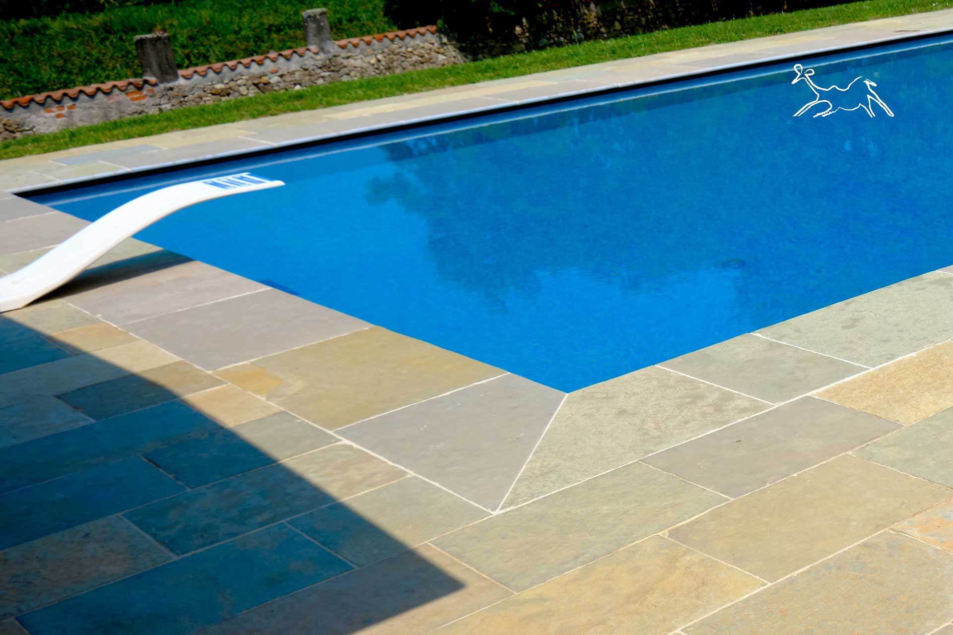 piscina realizzata da The Stone Age Exclusive a Brescia con con bordo piscina in pietra Terra Toscana a costa toro