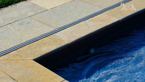angolo bordo piscina in pietra Terra Toscana con finitura a toro arrotondata e superficie antiscivolo realizzato a Pavia