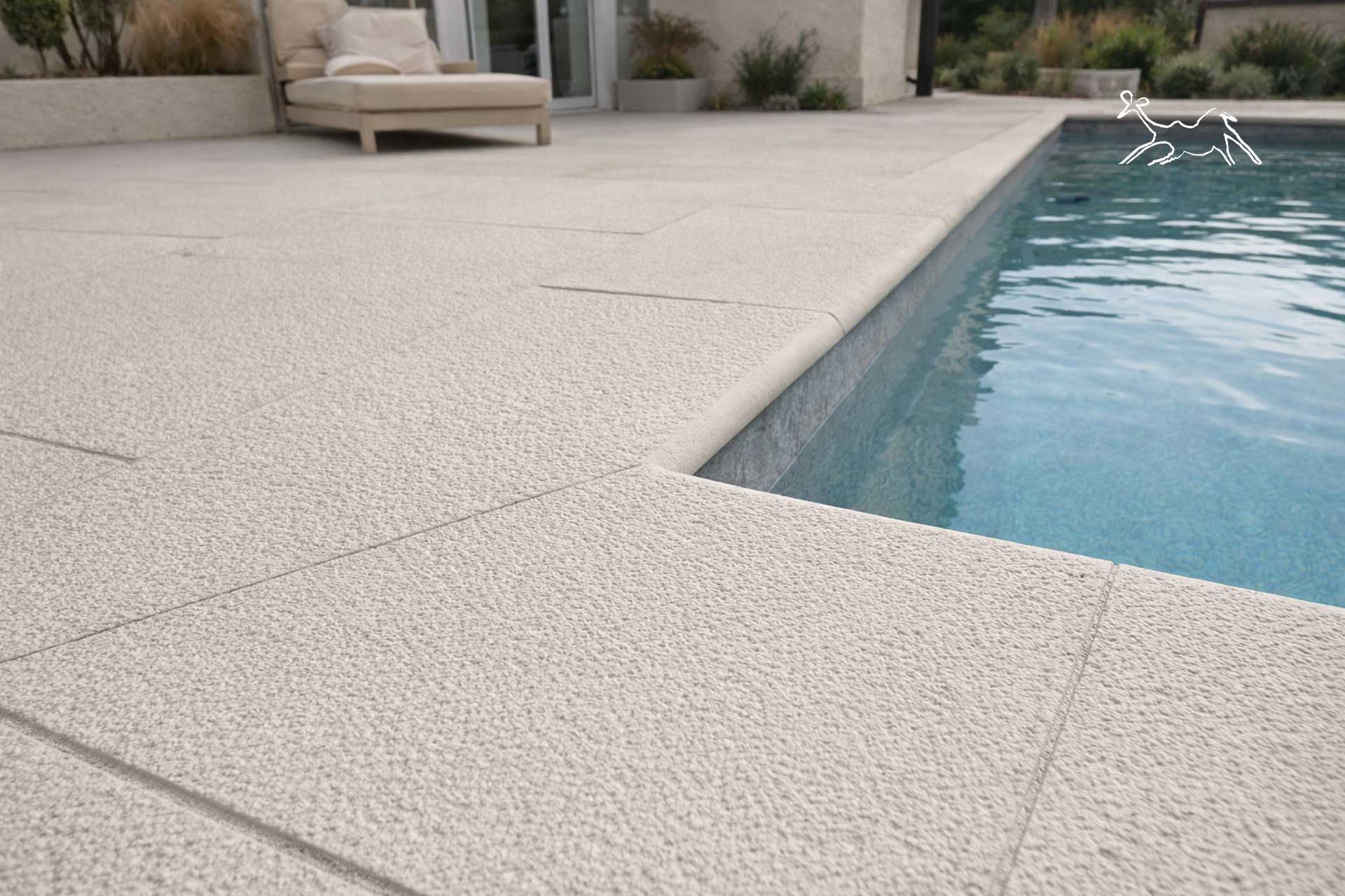 solarium moderno con bordo piscina in pietra quarzite chiara effetto sabbia caraibica