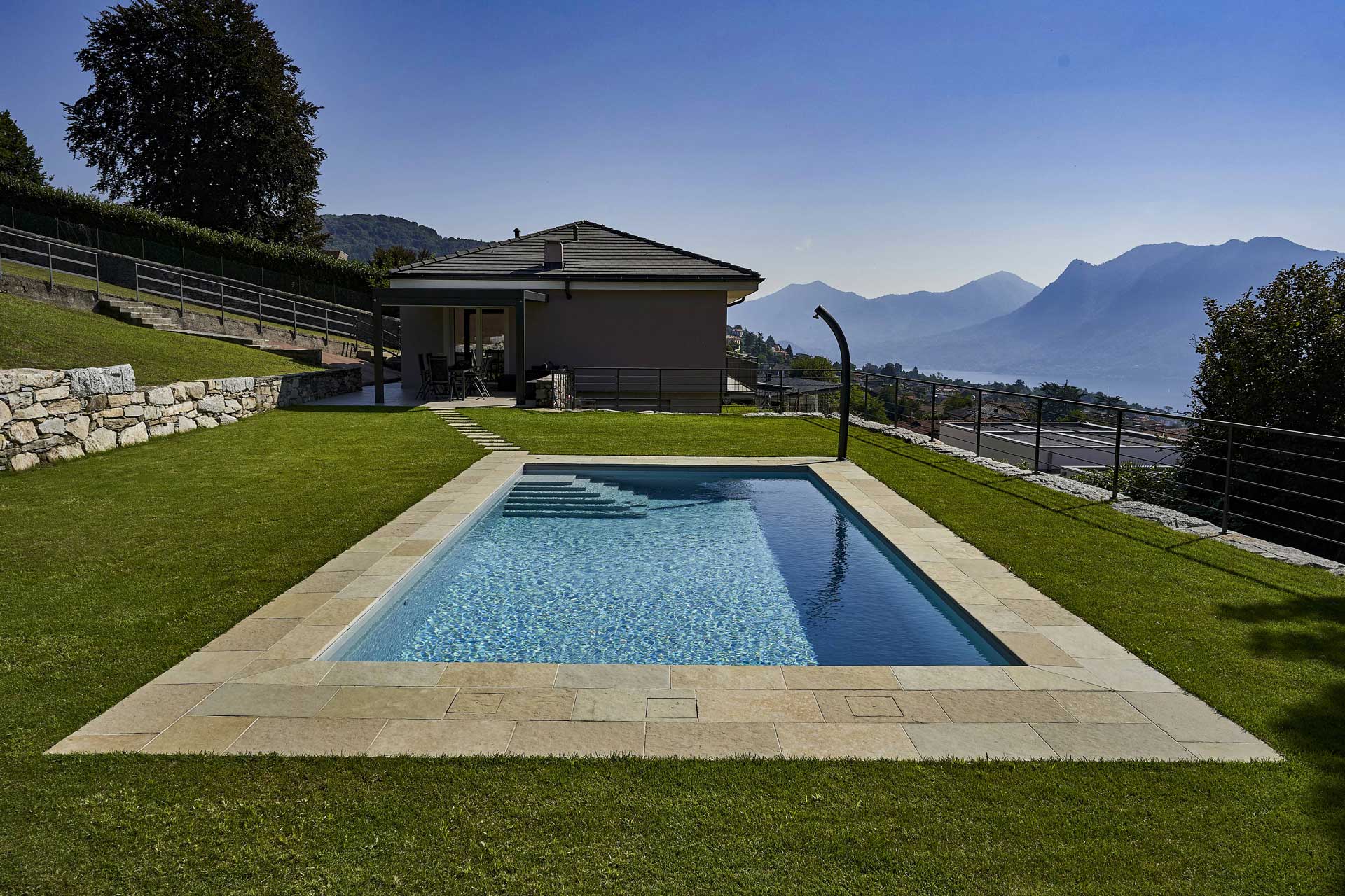 Piscina con pavimento e bordo in pietra Versilia Brown a Verbania