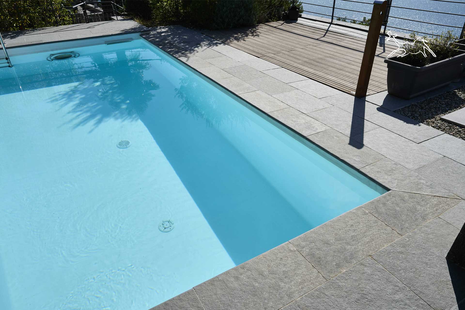 piscina con interno azzurro e contorni in piastrelle di pietra grigia naturale in casa privata a Bellagio sul lago di Como